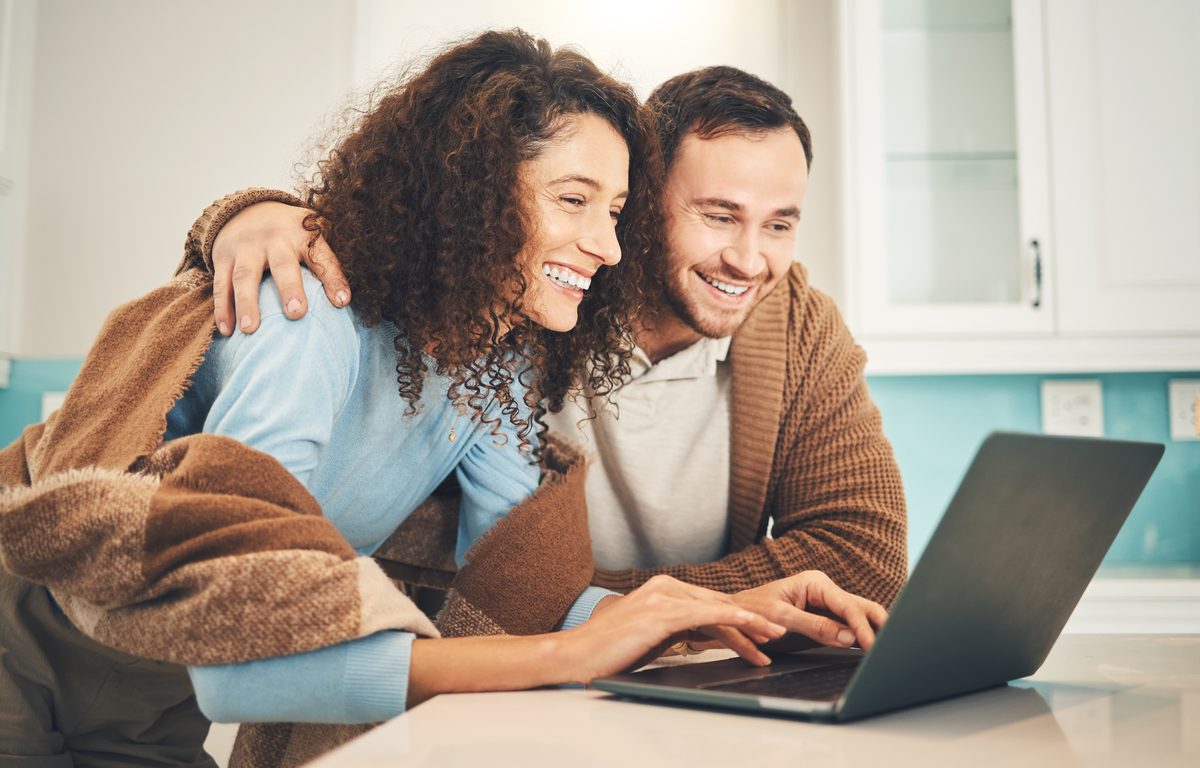 Junges Paar gestaltet Eheringe gemeinsam am Laptop