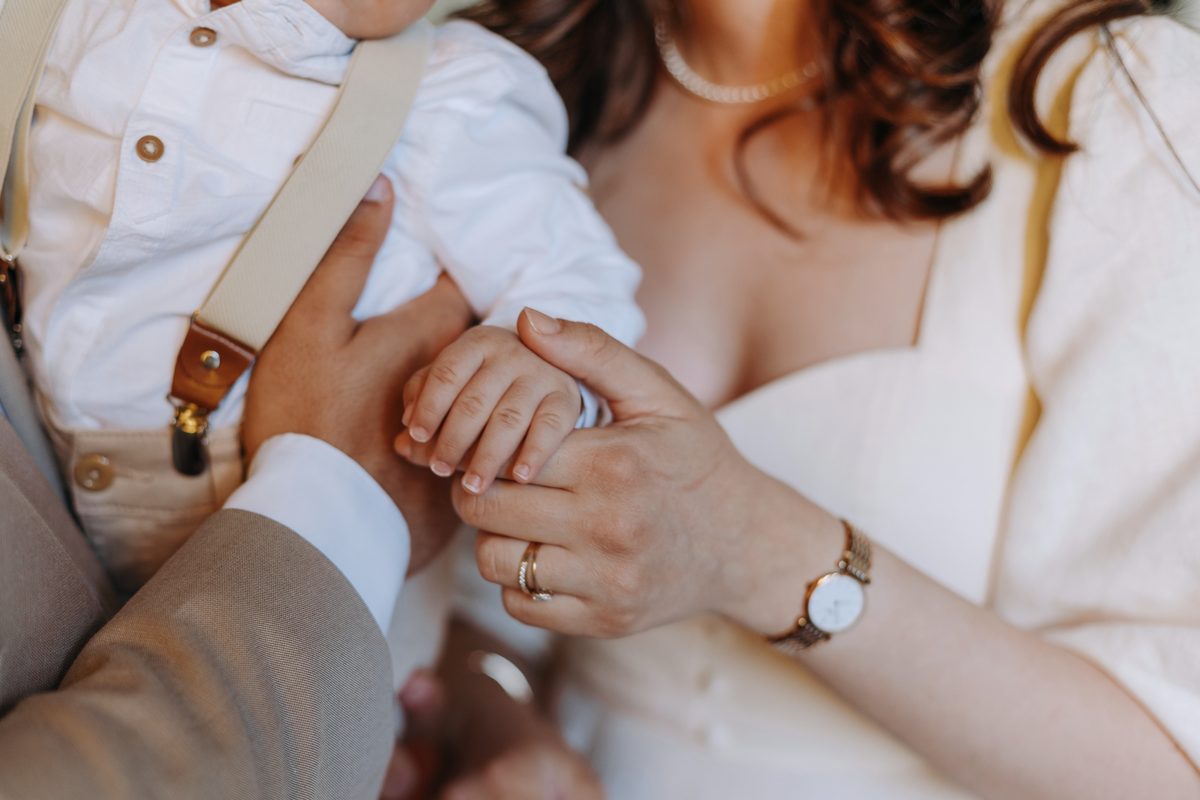 Familie mit Baby – Eheringe und Geburtssteine als Symbol für Liebe und Zusammenhalt