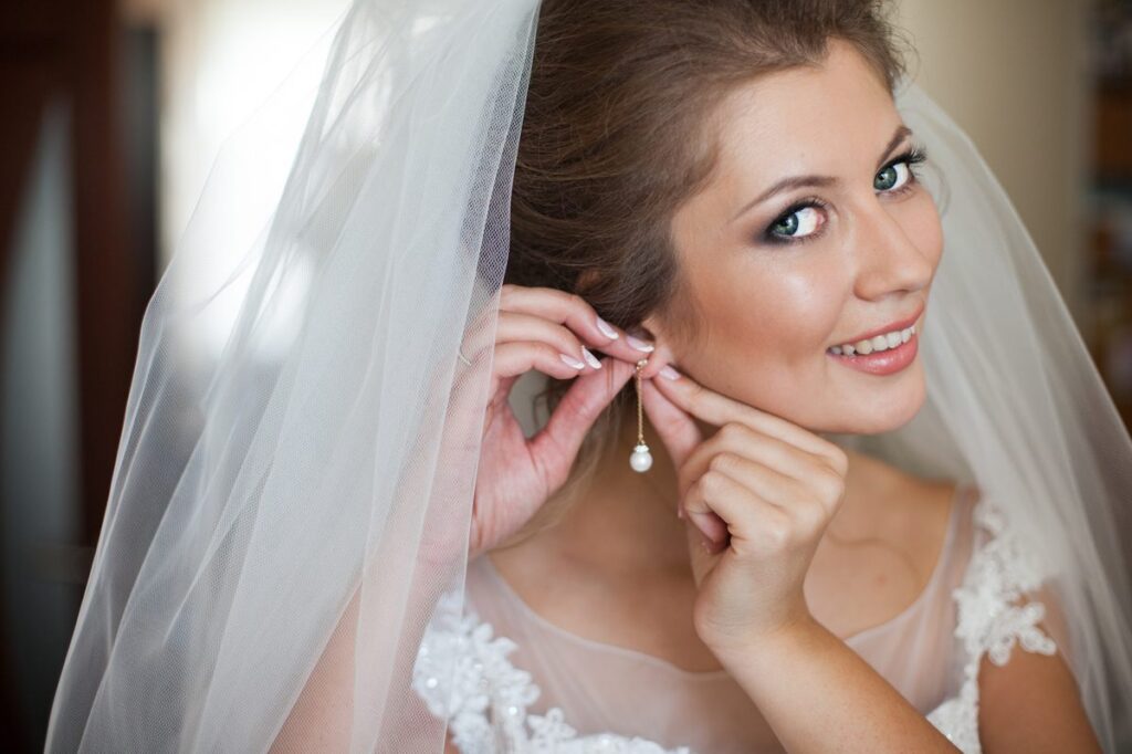 Braut legt Ohrringe an – Getting Ready am Hochzeitsmorgen